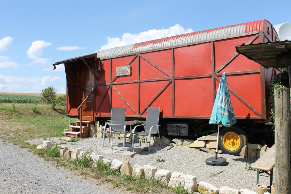 un wagon rouge assis sur le côté d'une route dans l'établissement Rolling Home, à Eppingen