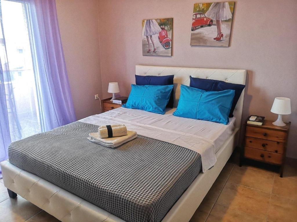 a bedroom with a large bed with blue pillows at Nikiti Spathies Resort - Maizonette at Nikiti Village in Nikiti