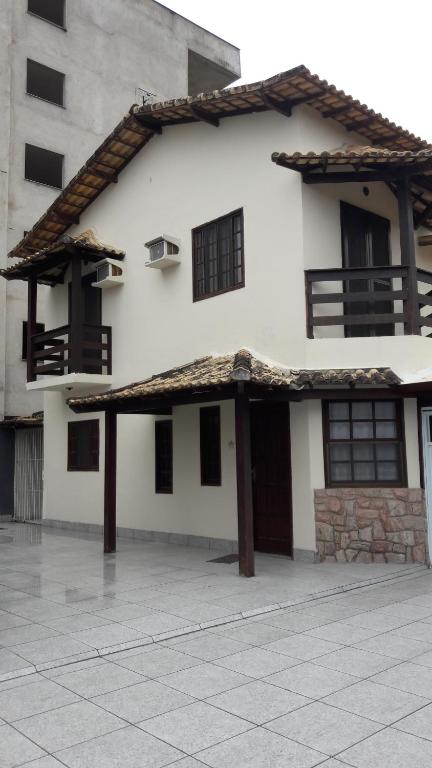 a large white building with a roof at Casa Temporada Rio das Ostras in Rio das Ostras