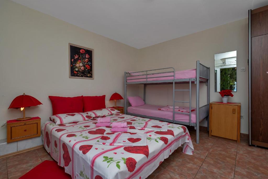 een slaapkamer met een bed en een stapelbed bij Vila Milena in Krvavica