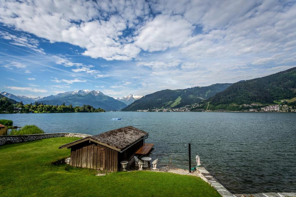 a house on the shore of a lake with mountains at See 58 in Zell am See