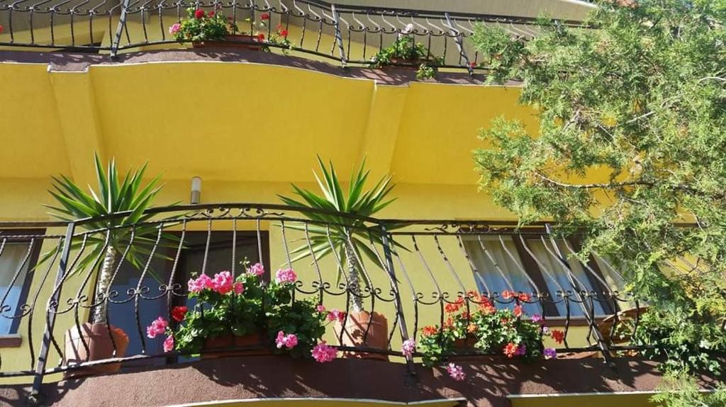 a balcony with flowers and plants on a yellow building at Casa di Madi in 2 Mai