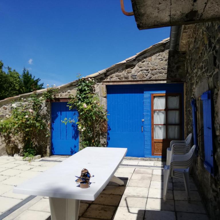une table blanche devant un garage bleu dans l'établissement les écureuils, à Saint-Priest