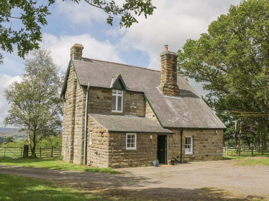 an old stone house with a chimney on top at Westonby Lodge in Whitby