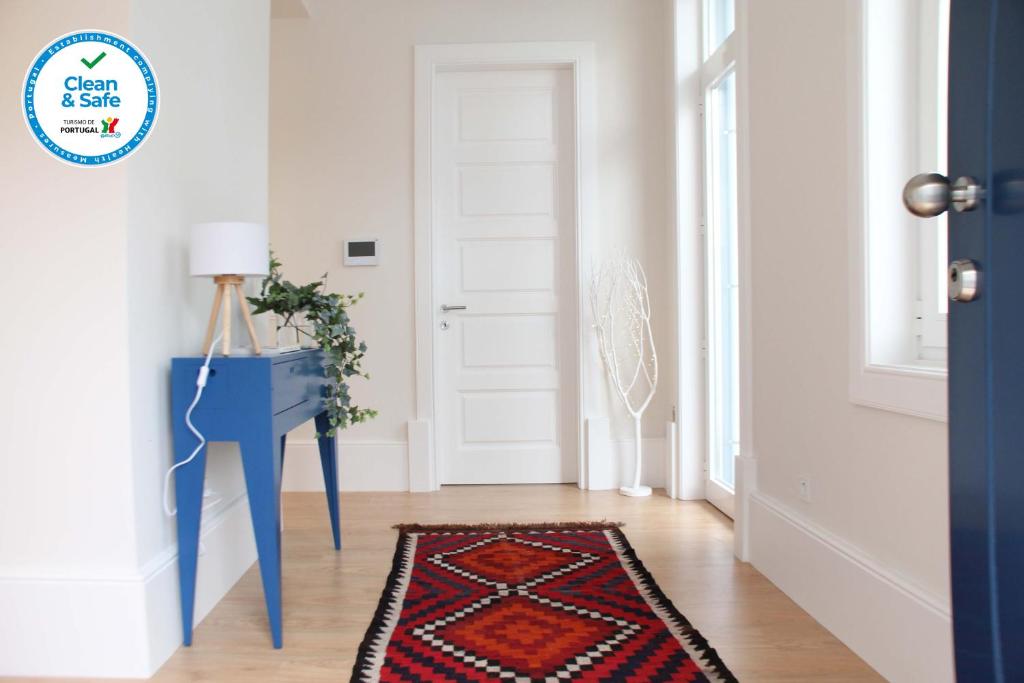 een hal met een blauwe deur en een tapijt bij Blue Twenty Two - Espinho / Oporto Beach in Espinho