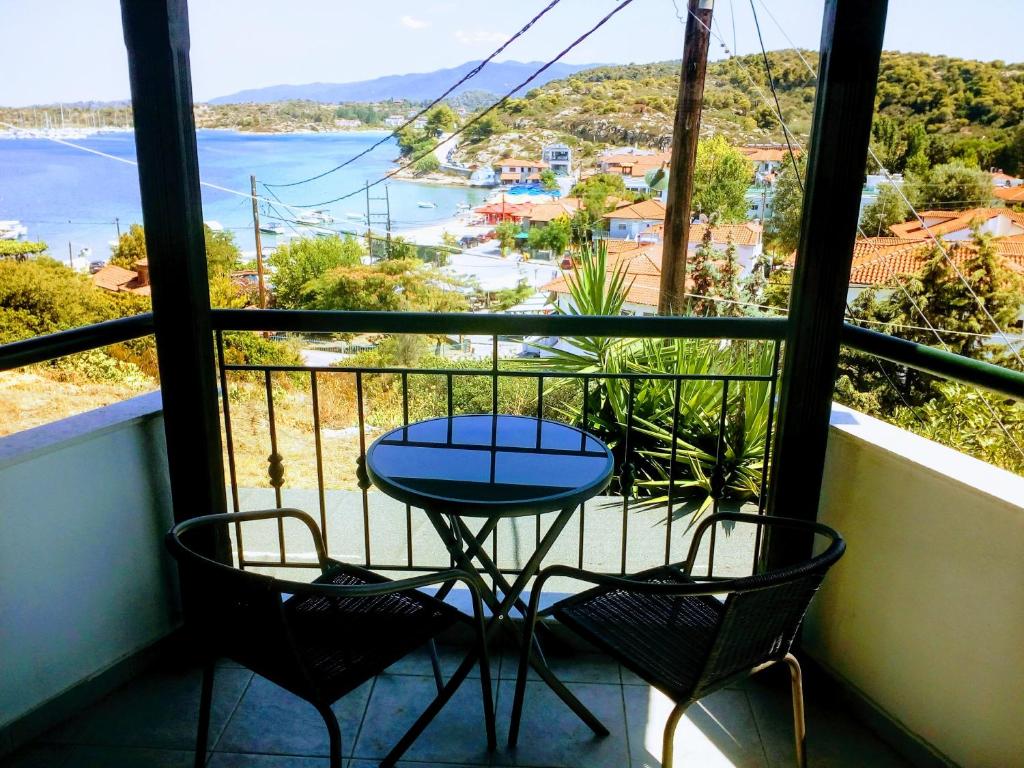 un tavolo e sedie su un balcone con vista sull'acqua di Dasea Houses a Ormos Panagias