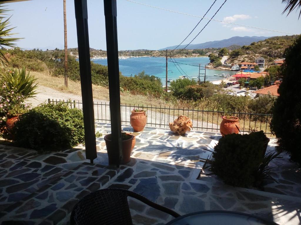 a view of the ocean from a balcony with potted plants at Dasea Houses in Ormos Panagias
