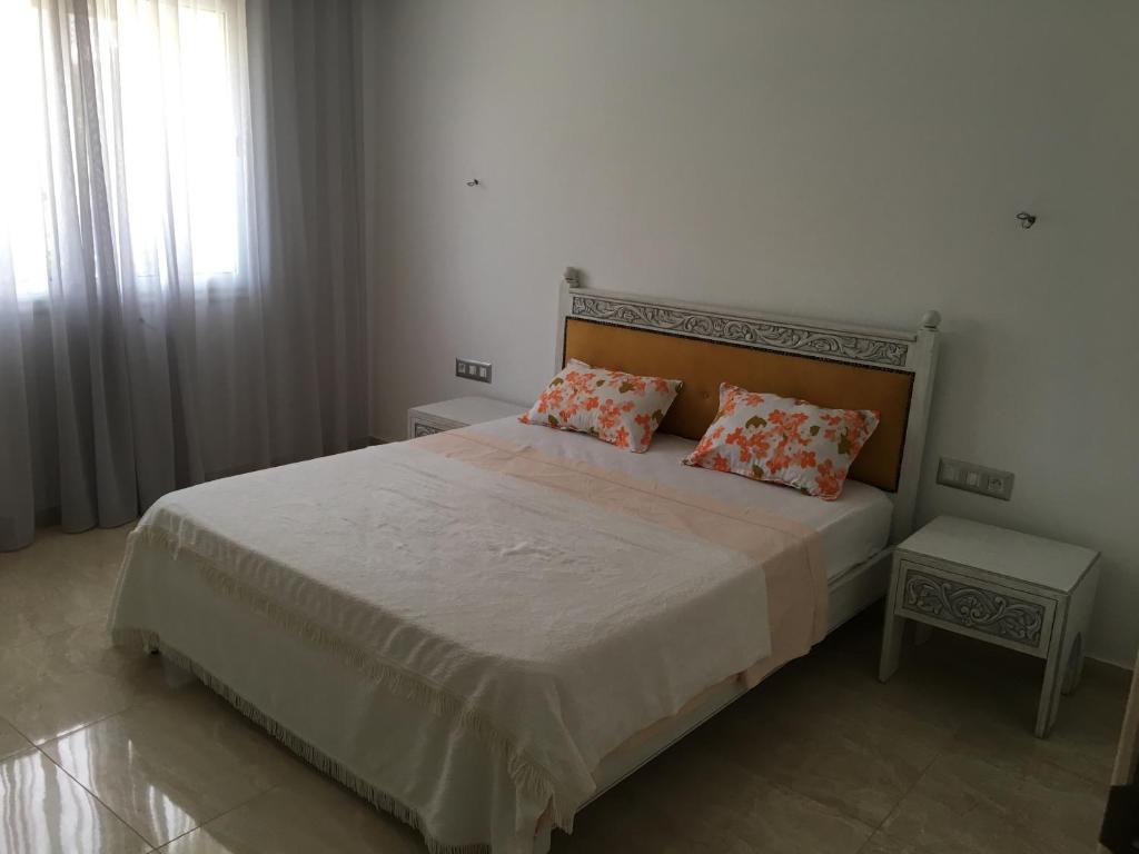 a bedroom with a large bed with two pillows at Arabesque Style - 2 appartements in Kelibia
