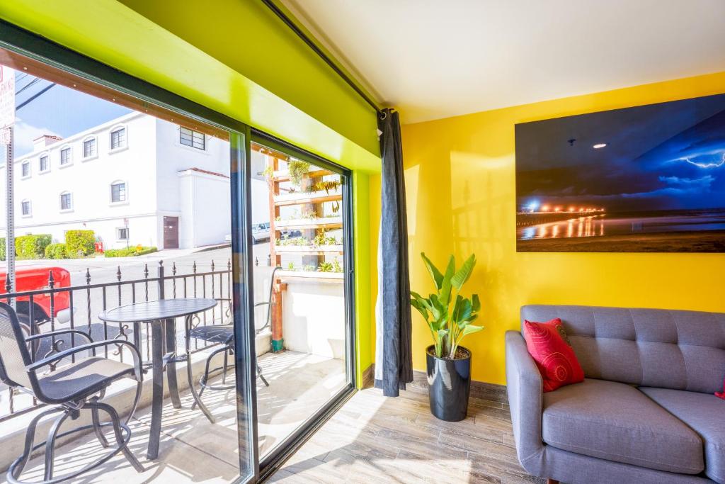 a room with a balcony with a couch and a table at Nomads Hotel in San Clemente