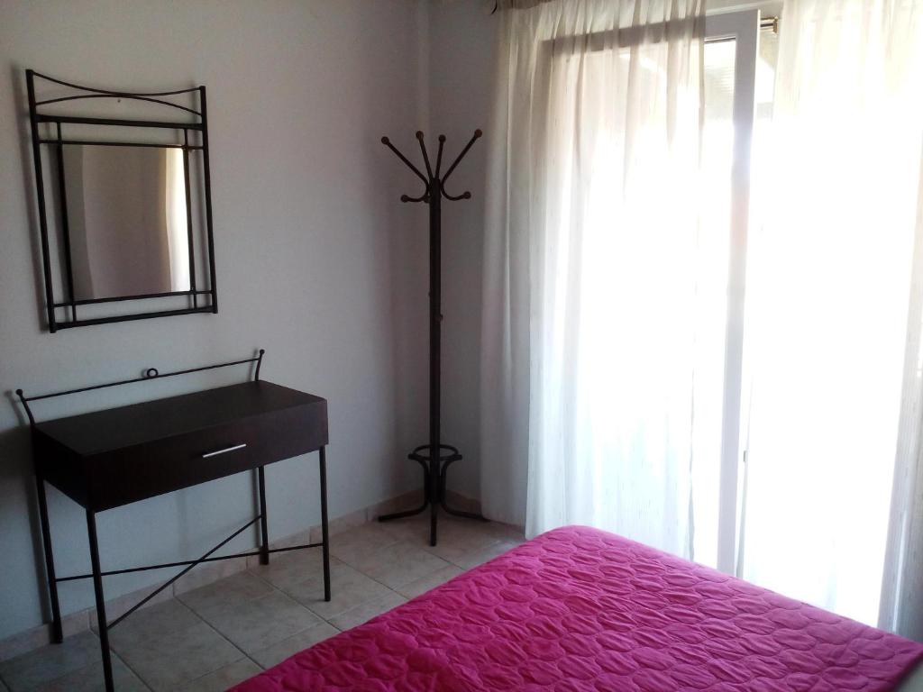 a bedroom with a bed and a dresser and a mirror at Dasea Houses in Ormos Panagias