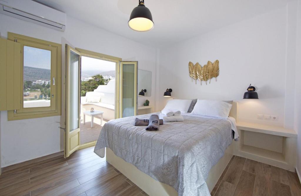 a bedroom with a bed and a large window at Diasino Apartments and Car Rental in Katapola