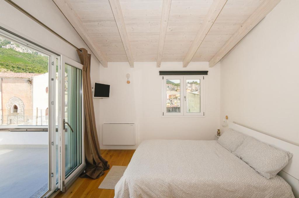 a bedroom with a bed and a window at Tatta & Nanna Rooms in Oliena