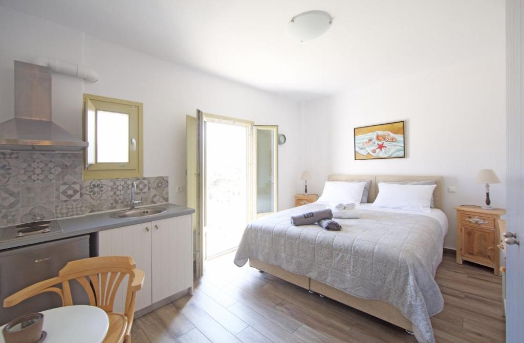 a bedroom with a bed and a table and a kitchen at Diasino Apartments and Car Rental in Katapola