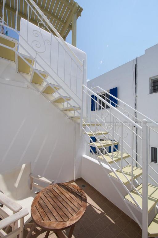 a wooden bench next to a spiral stair case at Diasino Apartments and Car Rental in Katapola