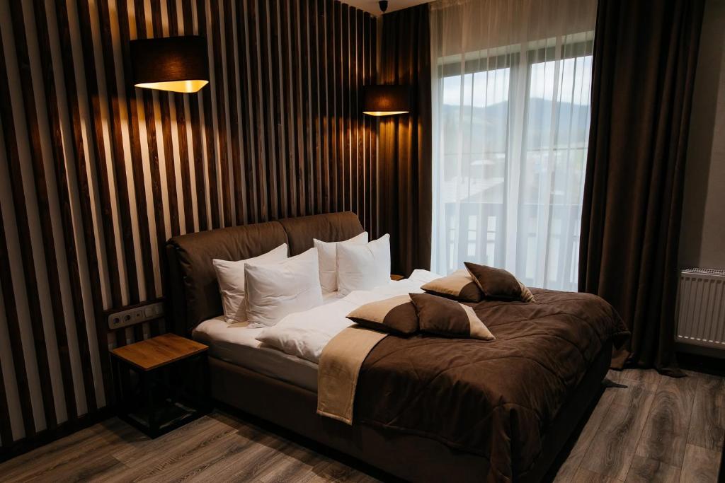 1 dormitorio con cama con almohadas y ventana en CHALET NEBO en Bukovel