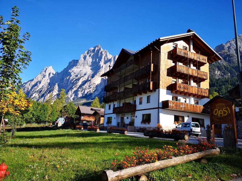 een groot gebouw voor een berg bij Hotel Oasi in San Vito di Cadore