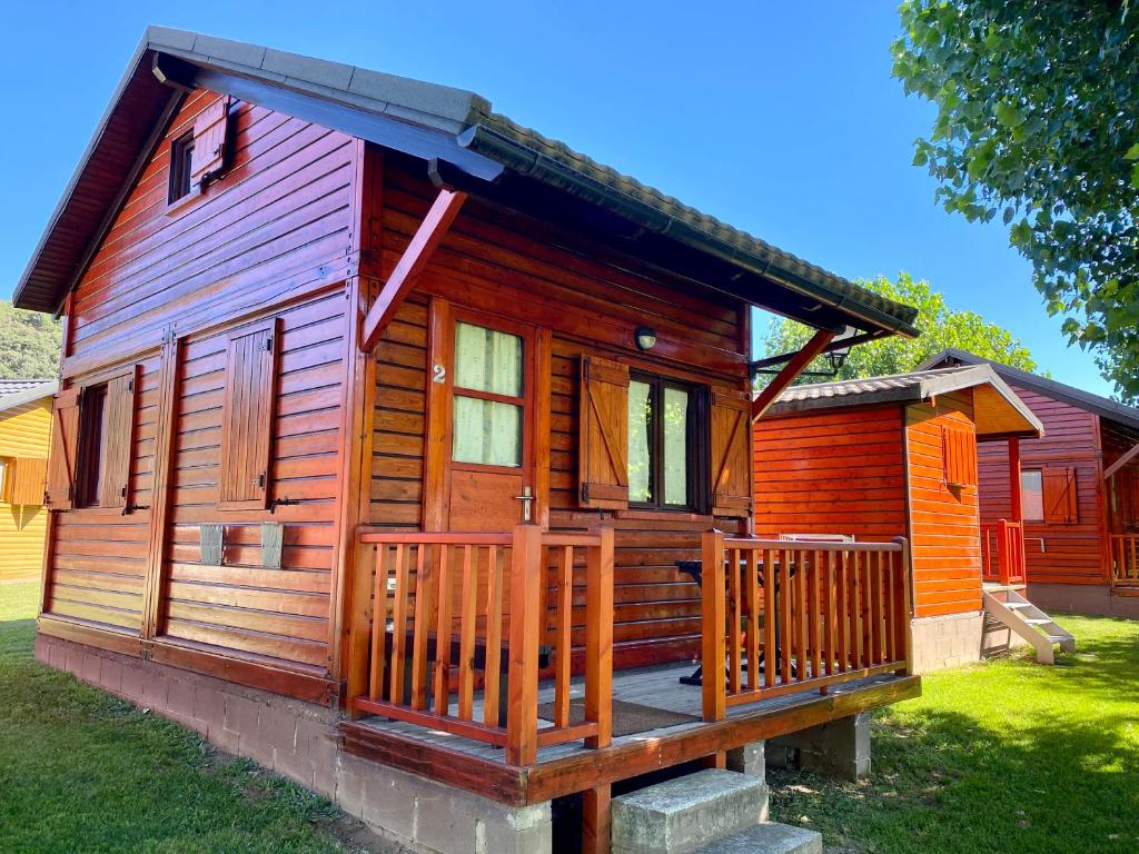 Ce chalet en bois dispose d'une véranda et d'une terrasse. dans l'établissement Camping Gran Sol, à Montferrer