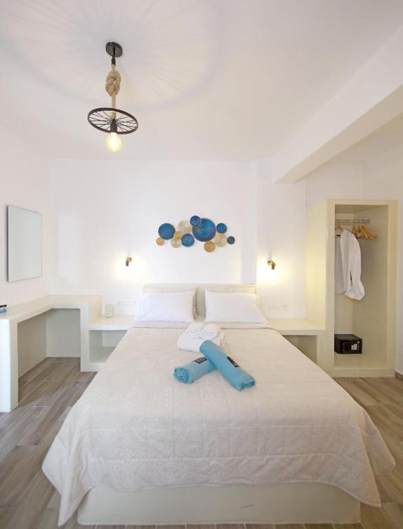 a bedroom with a large white bed with a blue object on it at Diasino Apartments and Car Rental in Katapola