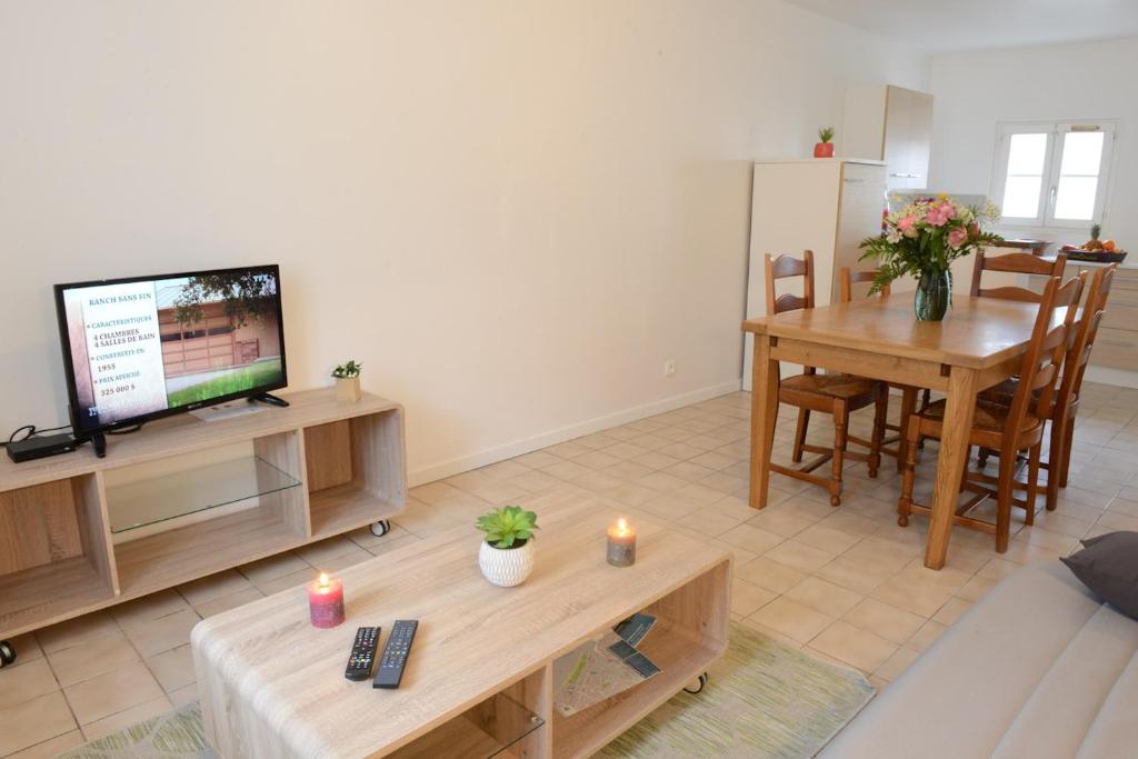 een woonkamer met een televisie en een tafel met kaarsen bij Le Cerf-Volant in Dieppe