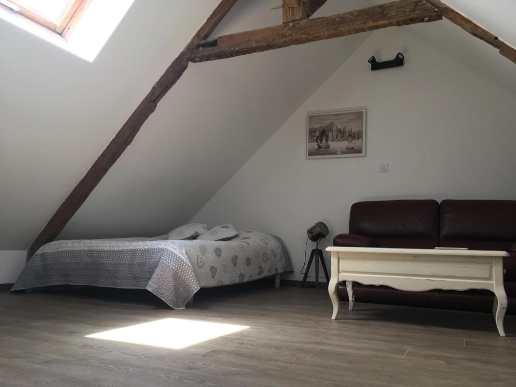 1 dormitorio con 1 cama y 1 sofá en el ático en Appartement L'Arédien, en Saint-Yrieix-la-Perche