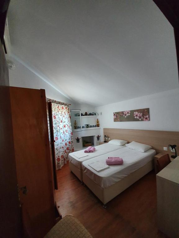 a bedroom with two beds with pink towels on them at Dionisos Studios and Apts Skiathos in Koukounaries