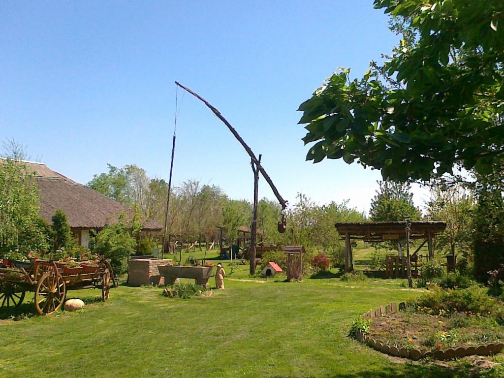 etno kuća Đeram في Mokrin: حديقة فيها رمح كبير في العشب