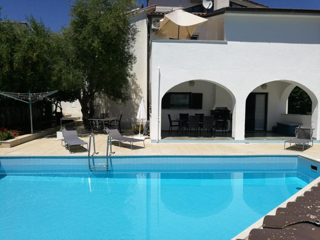 a swimming pool in front of a villa at Ferienhaus Bozena Appartment 2 in Vrsar