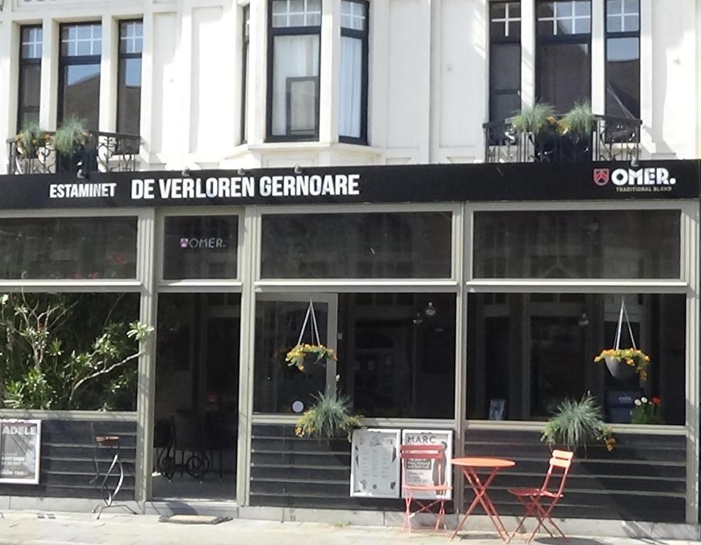 un restaurante con mesas y sillas frente a un edificio en De Verloren Gernoare en De Panne