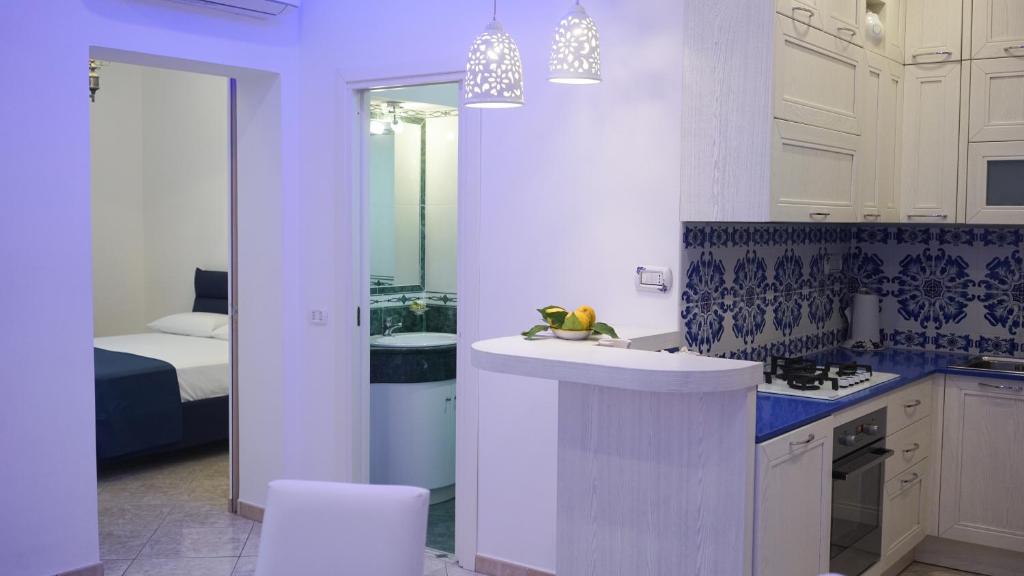 eine Küche mit einem Waschbecken und ein Schlafzimmer mit einem Bett in der Unterkunft Mira Vico Apartments in Vico Equense