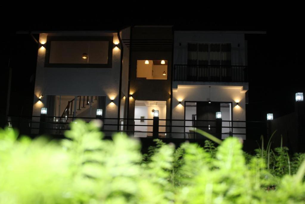 a house lit up at night with lights on it at Ivy Bungalow in Nuwara Eliya