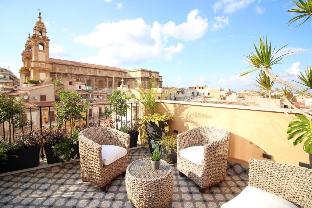 a balcony with chairs and a view of a city at Pànto - Rooftop boutique rooms in Palermo