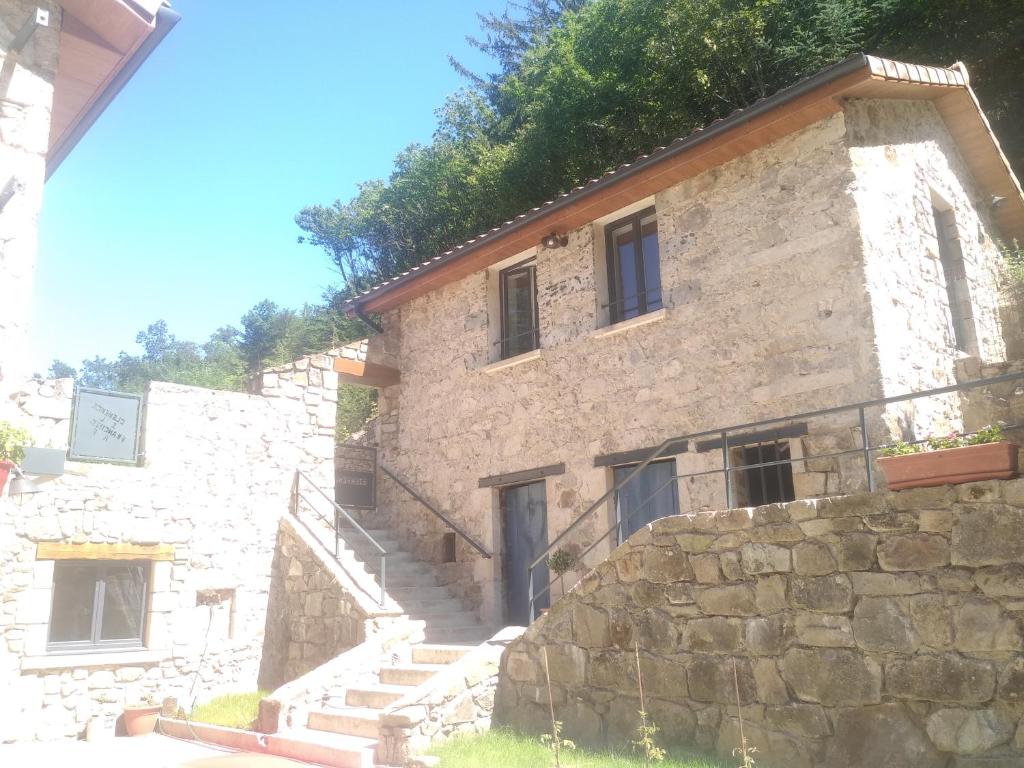 um edifício de pedra com escadas em frente em Gîte au coeur du parc naturel régional du Pilat em Pélussin