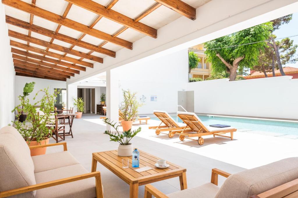 un patio al aire libre con sillas y una piscina en Hotel Patricia Menorca en Ciutadella