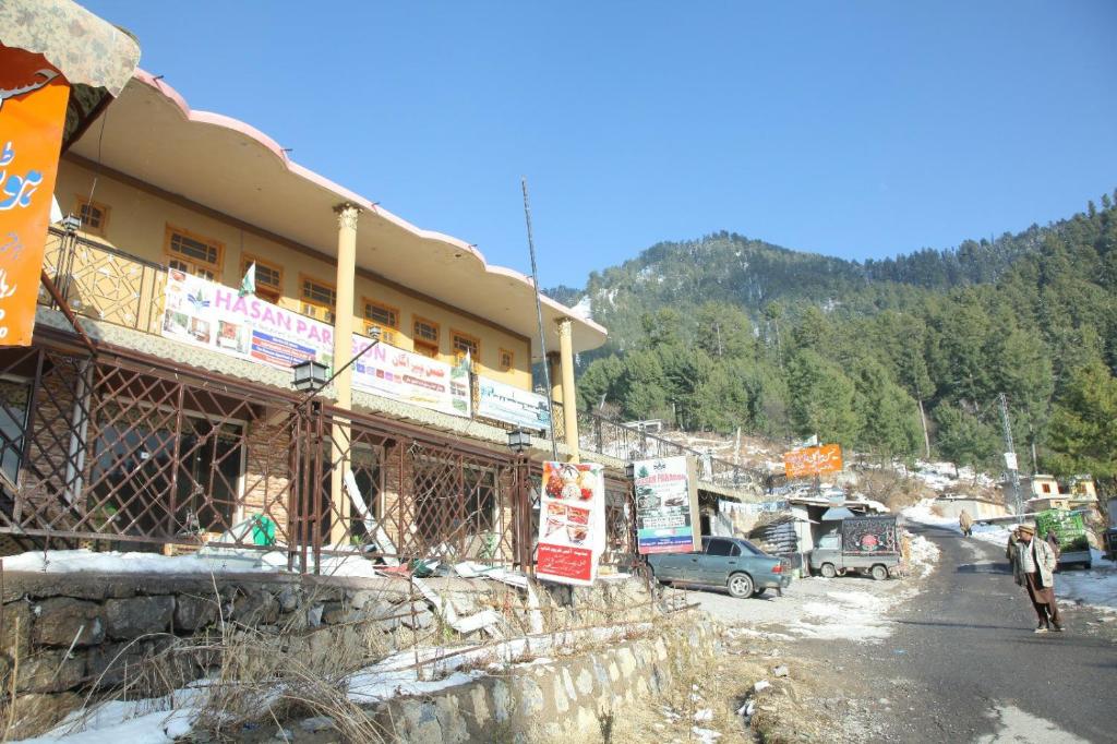 ein Gebäude an der Seite einer Straße neben einem Berg in der Unterkunft Hassan Hotel Thandani in Dhudiāl