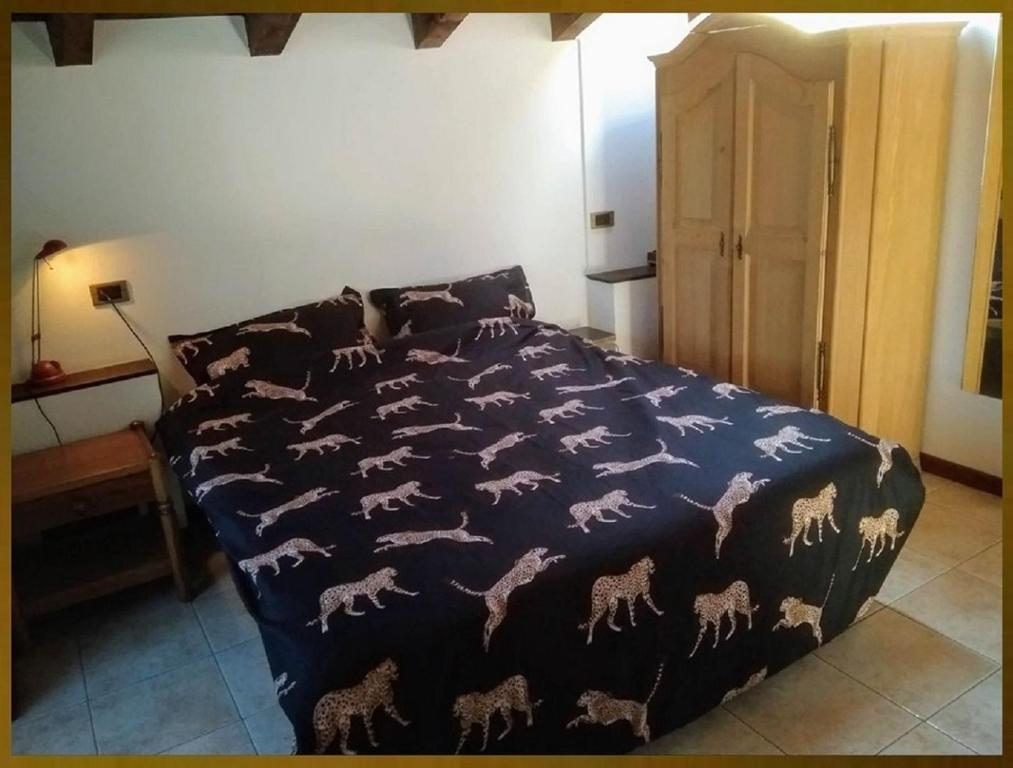 Una cama con una manta azul con caballos. en '' Al Pèrgul '', en Civo
