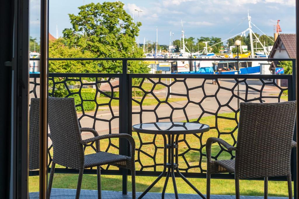 a table and chairs on a balcony with a marina at APARTAMENTY ZATOKA in Jastarnia