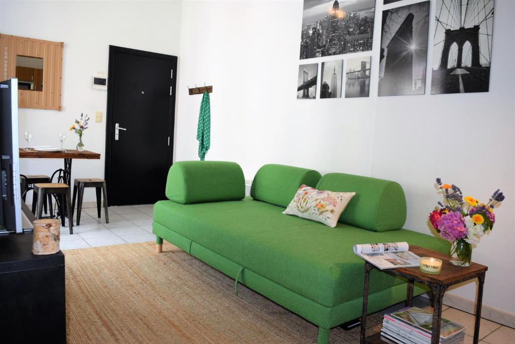 un sofá verde en una sala de estar con mesa en Cosy apartment in the center of Brussels, en Bruselas