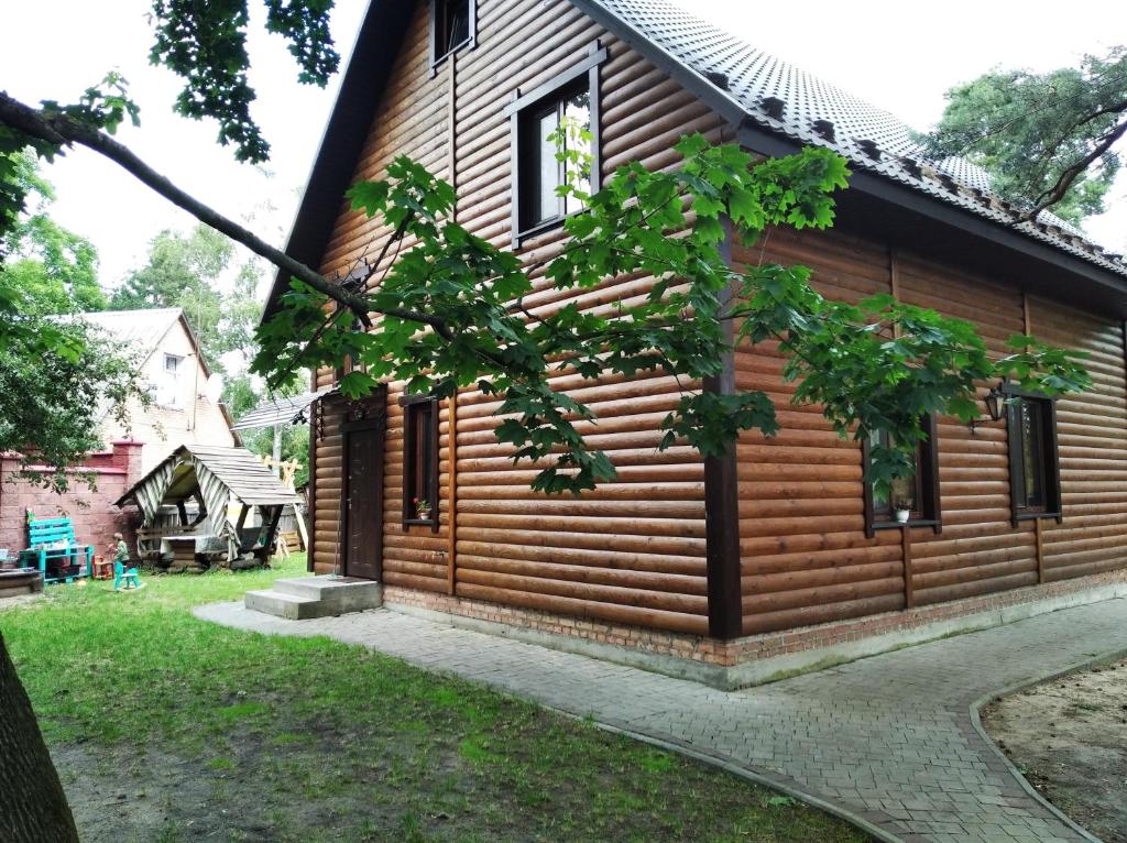 a wooden house with a tree in front of it at Садиба Орисин Явір Orysyn Yavir in Svityazʼ