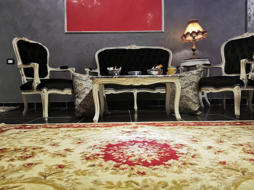 a living room with chairs and a table and a rug at Chic Apartment 2 in Sharm El Sheikh