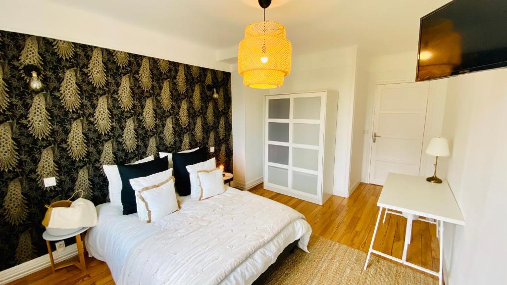 1 dormitorio con cama blanca y pared en blanco y negro en EL PARADISE - Coeur de Ville et Basilique au Balcon, en Lisieux