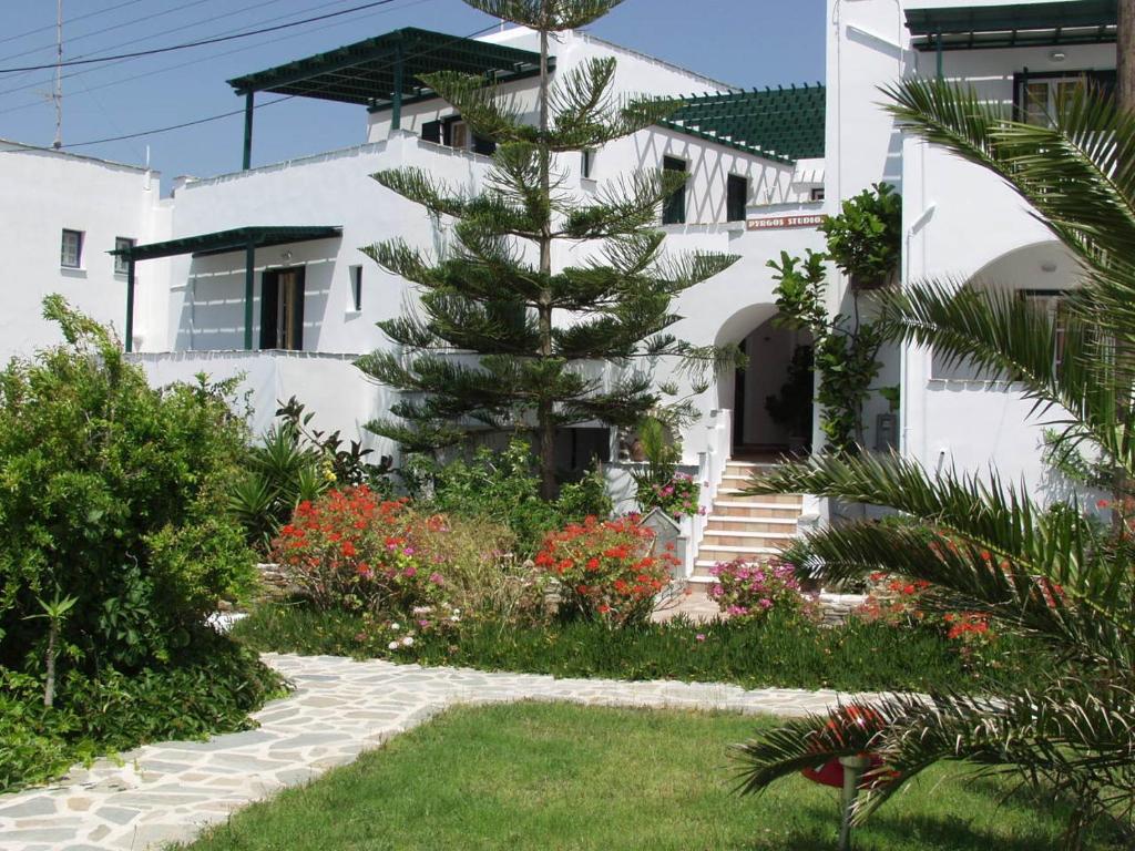 un pino di fronte a un edificio bianco di Pyrgos Beach ad Agios Prokopios