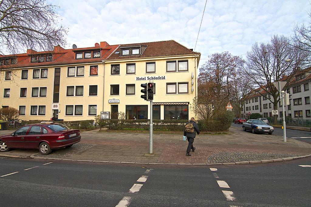 a person crossing a street in front of a building at Hotel Schönfeld in Bremen