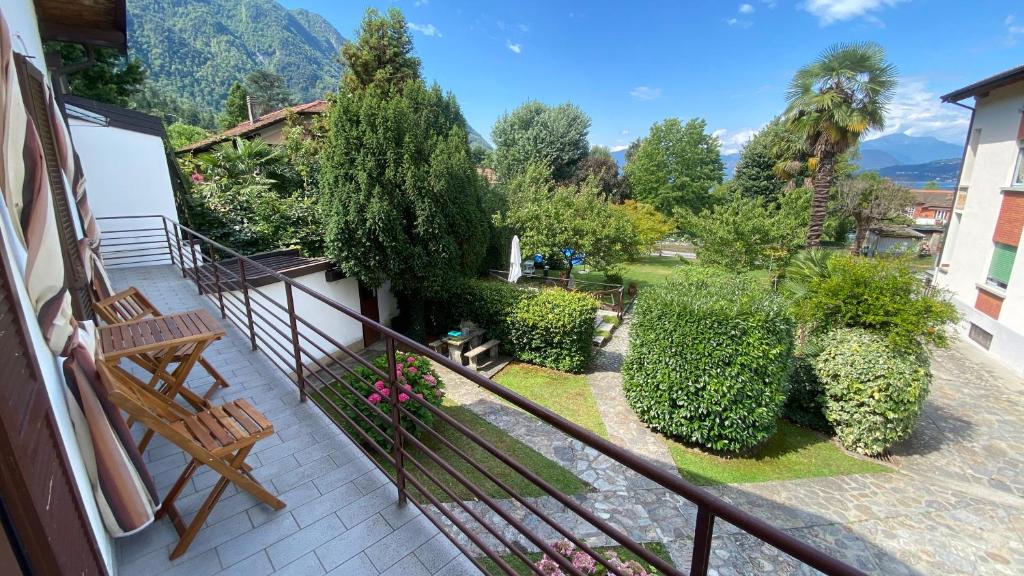 d'un balcon avec bancs, arbres et montagnes en arrière-plan. dans l'établissement Villa Vanda, à Castelveccana