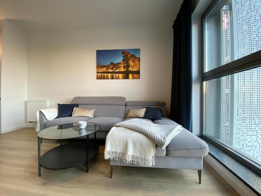 - un salon avec un canapé et une table dans l'établissement Granaria - Baltic Riviera Apartments, à Gdańsk