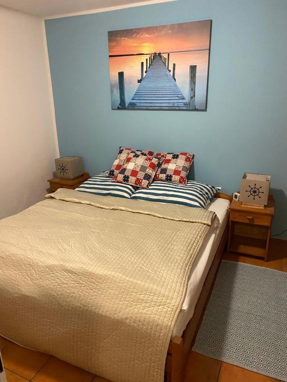 a bed in a room with a painting on the wall at Apartman Delfin in Senec
