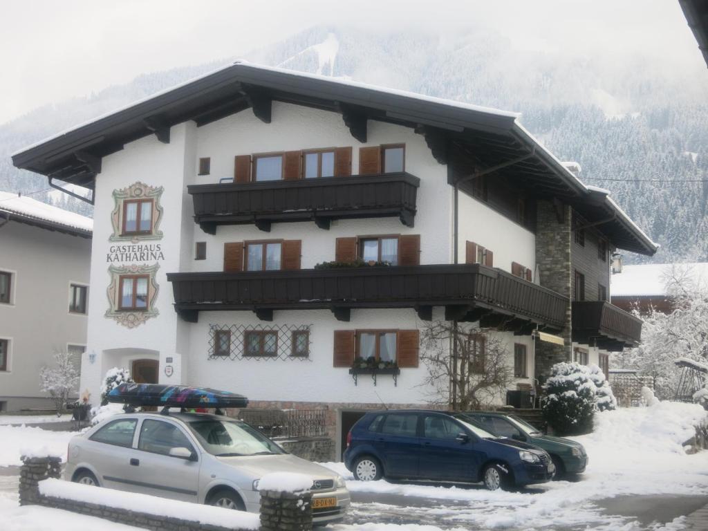 a snow covered building with cars parked in front of it at Haus Katharina in Westendorf