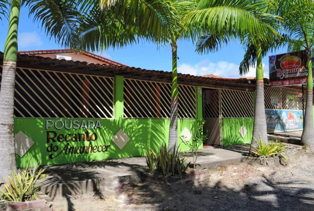 ein Resort mit Palmen vor einem Gebäude in der Unterkunft Pousada Recanto do Amanhecer in Porto De Galinhas