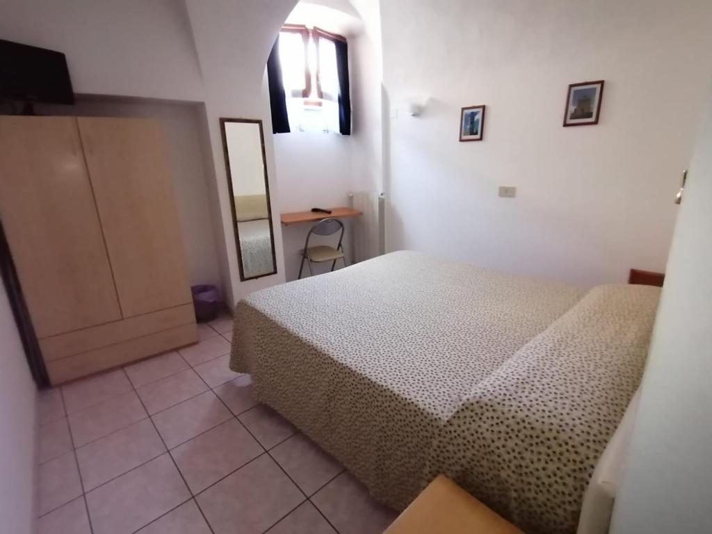a bedroom with a bed and a table and a mirror at Camere la torre in Volterra