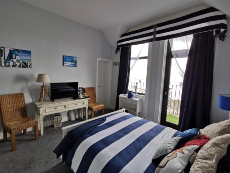 a bedroom with a bed and a desk and a window at Conlyn house in Newcastle