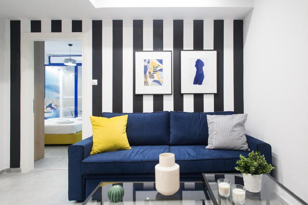 a living room with a blue couch and striped wall at LOMVARDOU-Stylish Flat next to Ampelokipi Metro St in Athens